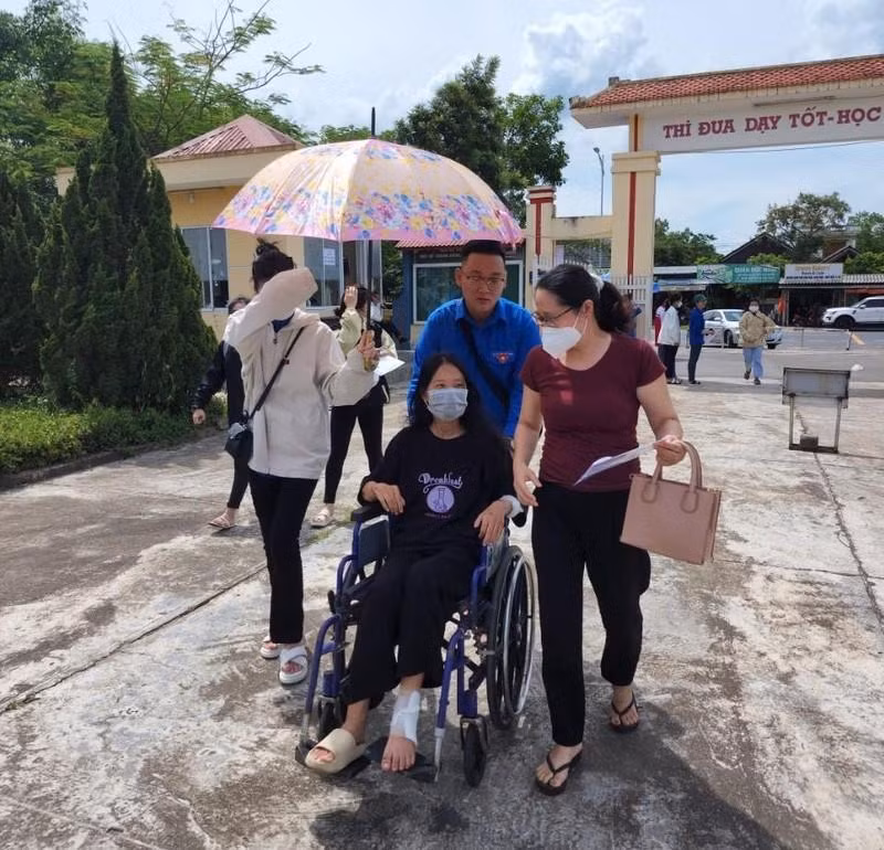 Thí sinh ngồi trên xe lăn đến trường thi. Ảnh: Đ.Đức