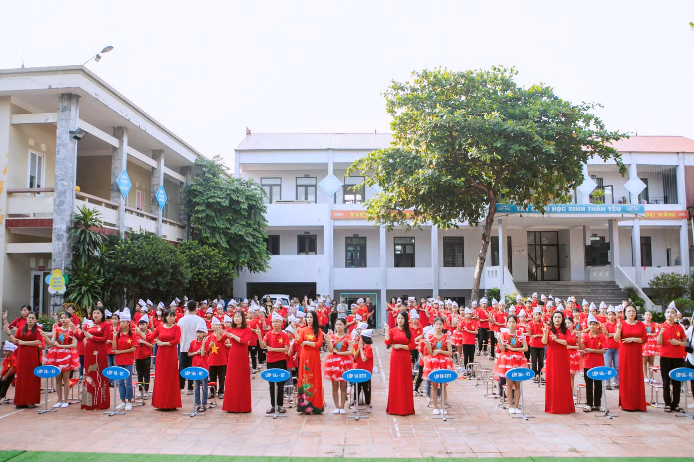 Các cô giáo cùng các em sử dụng ngôn ngữ tay thể hiện bài hát Quốc ca trong buổi lễ khai giảng.