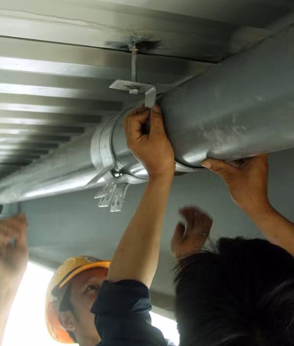 Các công nhân lắp dặt đường ống thoát nước dưới gầm cầu