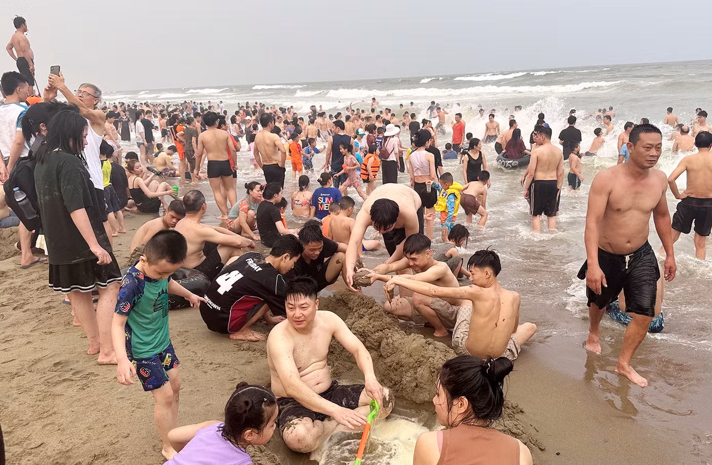 Sóng biển ở Sầm Sơn hôm nay khá lớn khiến nhiều du khách cẩn trọng không dám ra xa bờ. Một số người chỉ ngồi hóng mát hoặc chơi đắp cát gần bờ.