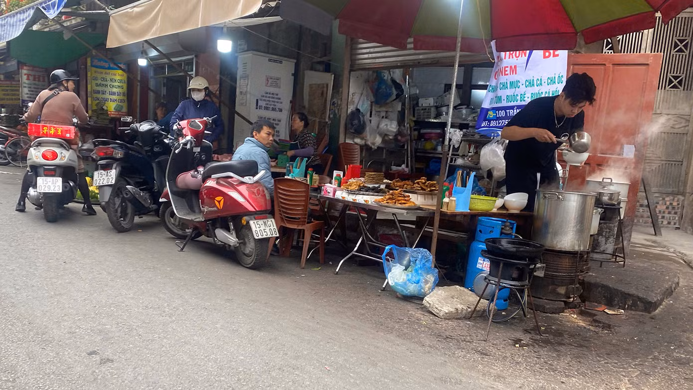 Một cửa hàng chả nem, bánh đa cua trên phố Trần Nhật Duật dùng cả bếp gas, bếp than nấu và bán dưới lòng đường, kế bên là cửa hàng thịt lợn.