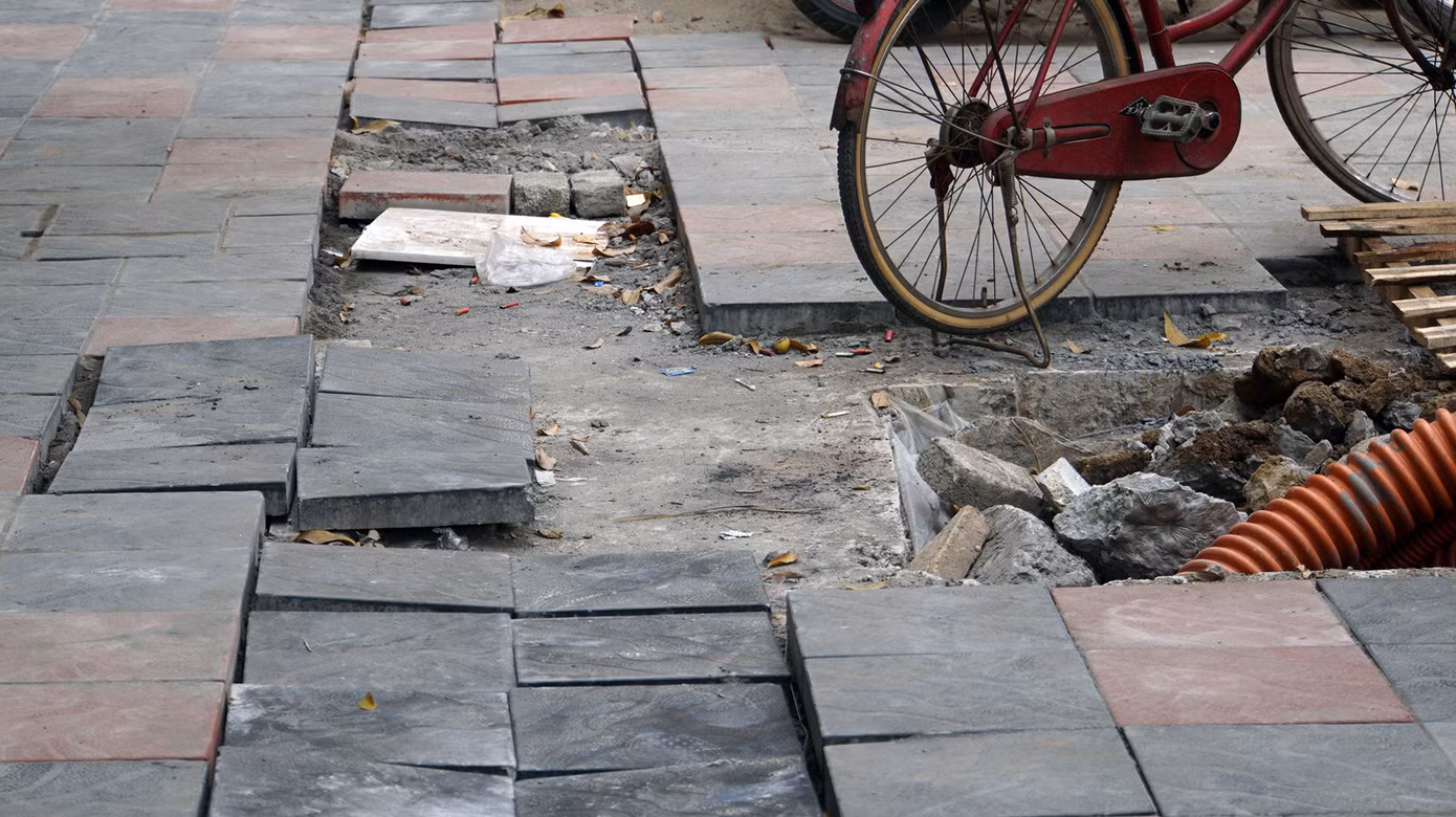 Do vật liệu ngổn ngang, đá lát dở dang trên vỉa hè khiến người dân cũng không còn lối đi bộ.