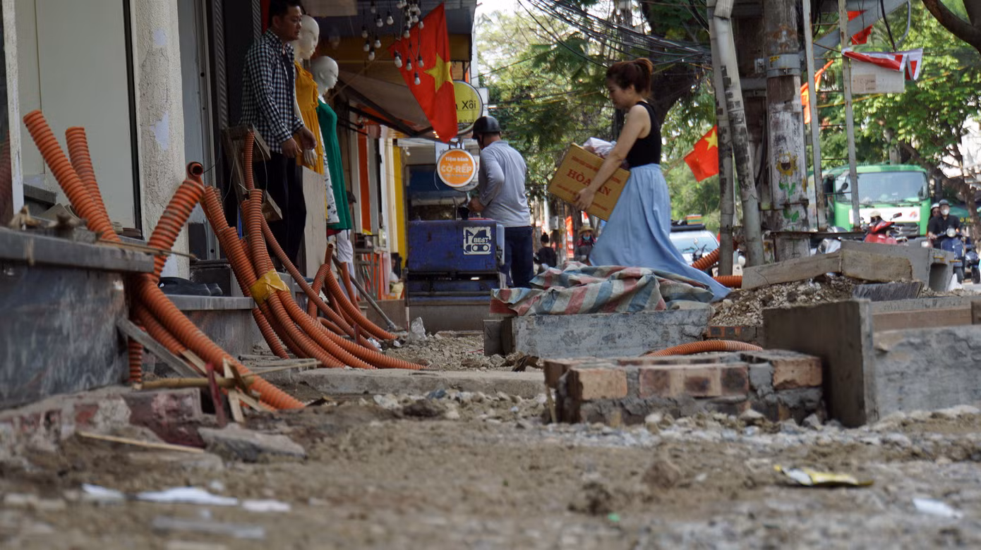 Người dân phố Lương Khánh Thiện chật vật di chuyển về nhà, vào cửa hàng. Một số người dân mưu sinh trên vỉa hè.