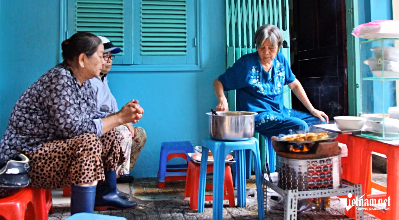 Tan chợ trưa, bà Hai (ngoài cùng bên trái) và bạn đến quán bánh khọt bé xíu của bà Lệ đợi mua bánh. Ảnh: Hà Nguyễn
