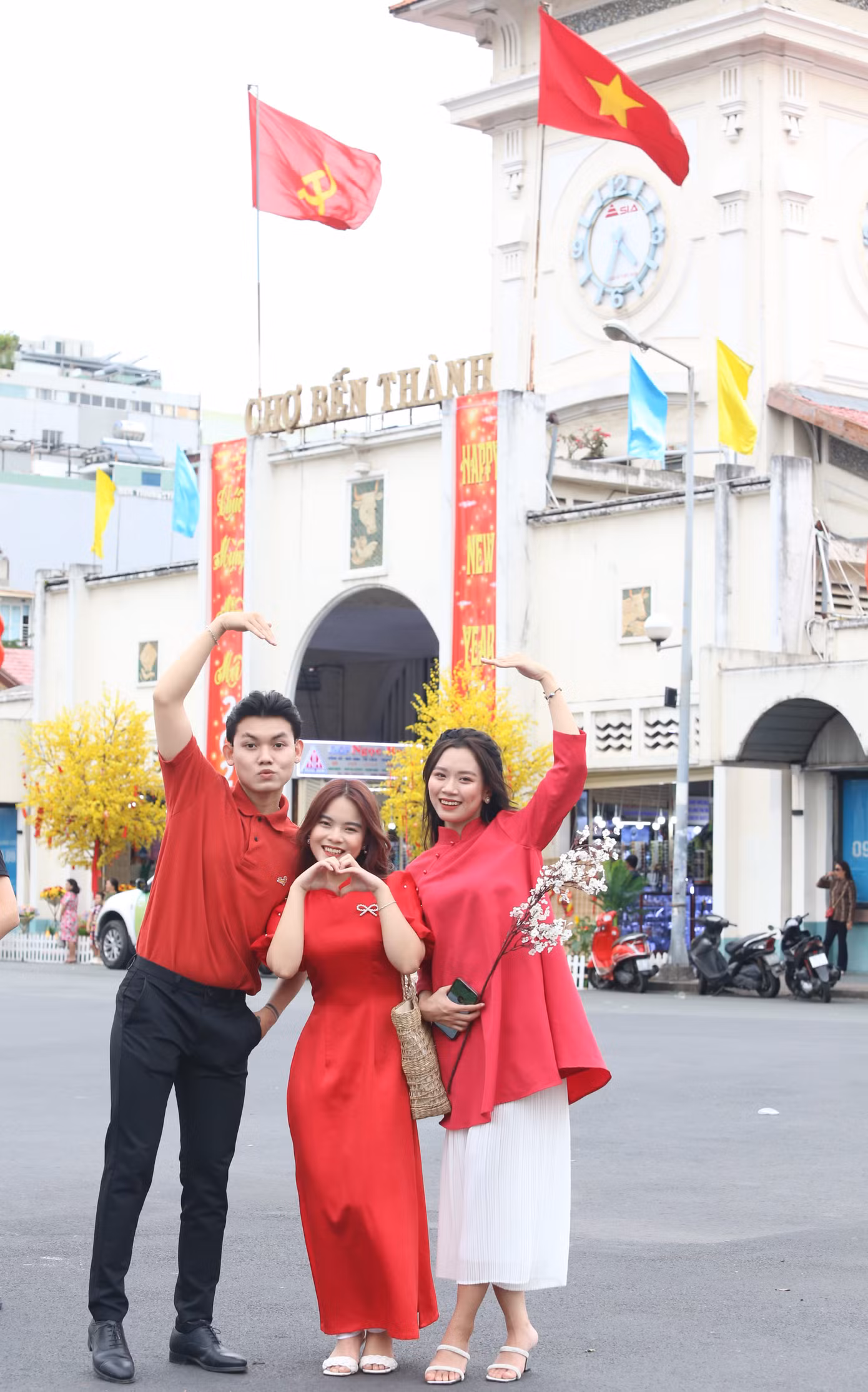 Chiều cuối năm, nhóm bạn Hiệp Cường (trái), Như Quỳnh (giữa, đều sinh viên Trường Đại học Công nghệ TPHCM) và Thanh Hoa (Trường Đại học Văn Lang) diện những bộ cánh rực rỡ chụp ảnh kỷ niệm với chợ Bến Thành ngay trước khi về quê đón Tết cùng gia đình.