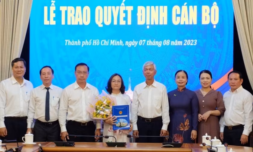 Phó Chủ tịch UBND TPHCM Võ Văn Hoan (thứ 4 từ phải qua) trao quyết định cho bà Nguyễn Thị Hương Giang. Ảnh: PLO