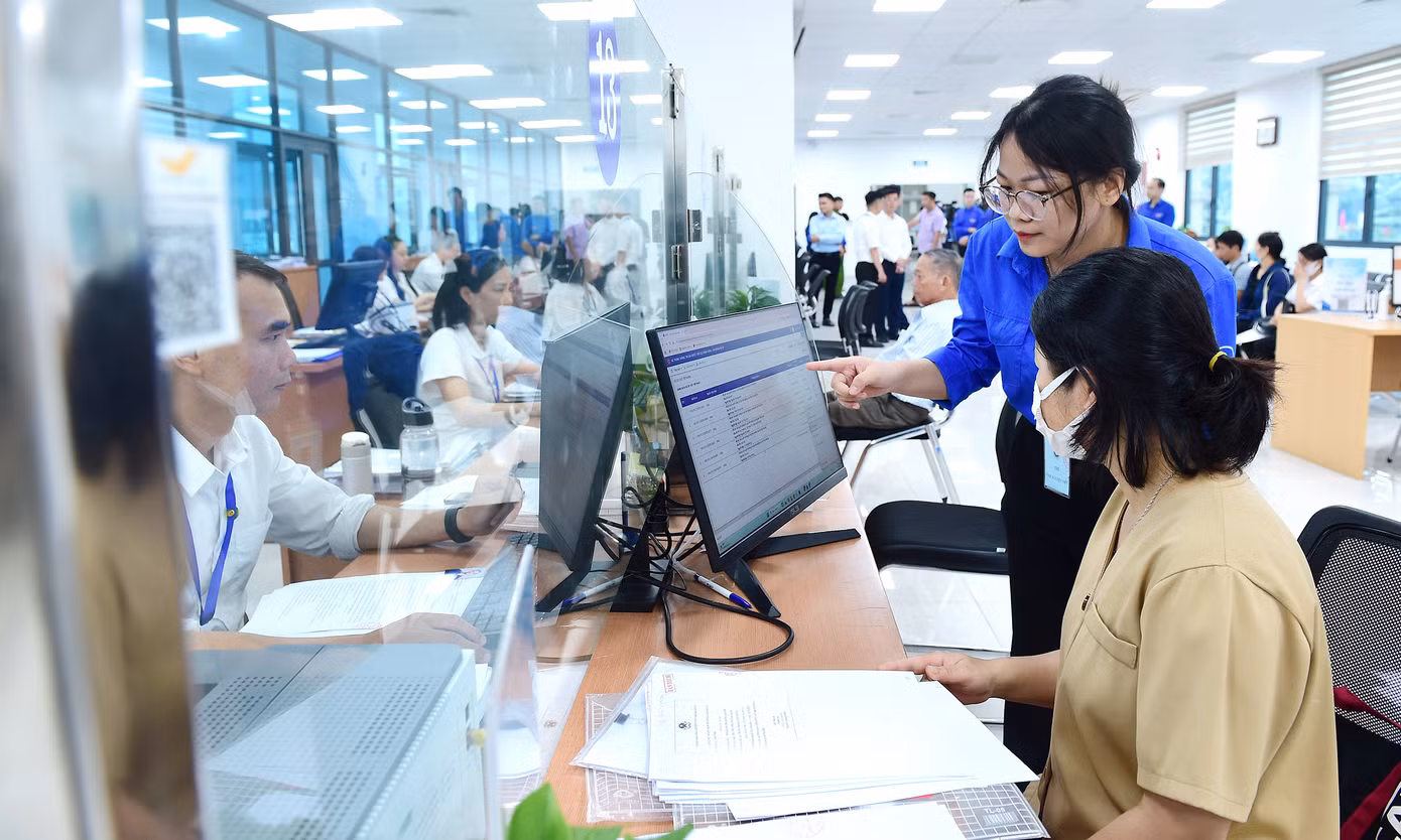 Tình nguyện viên hỗ trợ người dân đến làm thủ tục hành chính công tại phường Cầu Giấy. Ảnh: Xuân Tùng