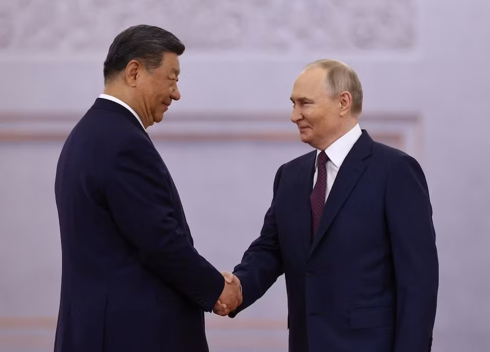 Lãnh đạo Nga - Trung Quốc bắt tay tại lễ đón. (Ảnh: Reuters)