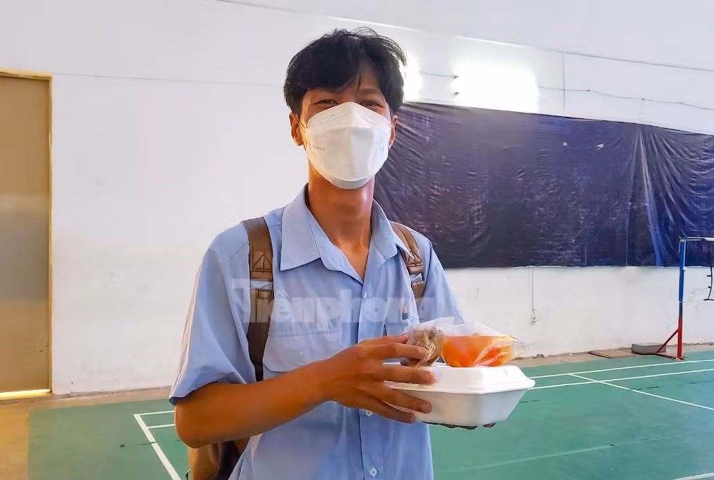 Một thí sinh phấn khởi nhận cơm sau khi làm bài thi - Ảnh: Kim Hà.