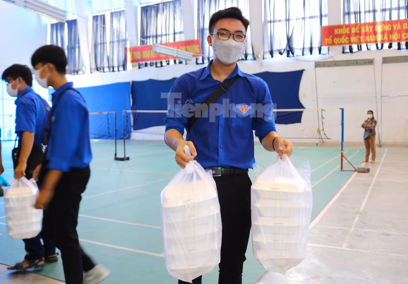 Lực lượng thanh niên tình nguyện hăng hái hỗ trợ vận chuyển suất ăn cho các thí sinh tại điểm thi Trường THPT Bùi Hữu Nghĩa - Ảnh: Kim Hà.