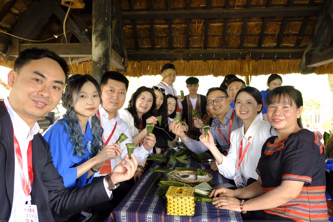 Đại biểu thanh niên Trung Quốc trải nghiệm phong tục gói bánh của người Xê đăng.