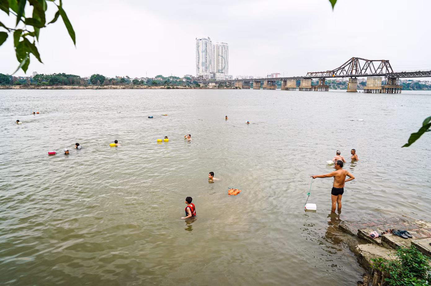 Tương tự, tại bãi tắm sông Hồng ở khu vực gần chân cầu Long Biên cũng thu hút rất đông người đến giải nhiệt.