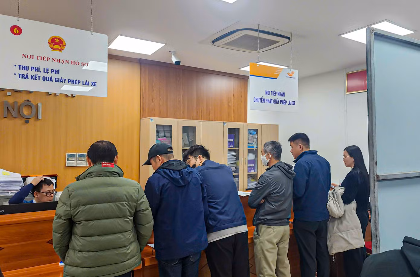 Phía bên trong khu vực cấp, đổi GPLX đông kín người dân ngồi chờ đến lượt được xử lý hồ sơ.