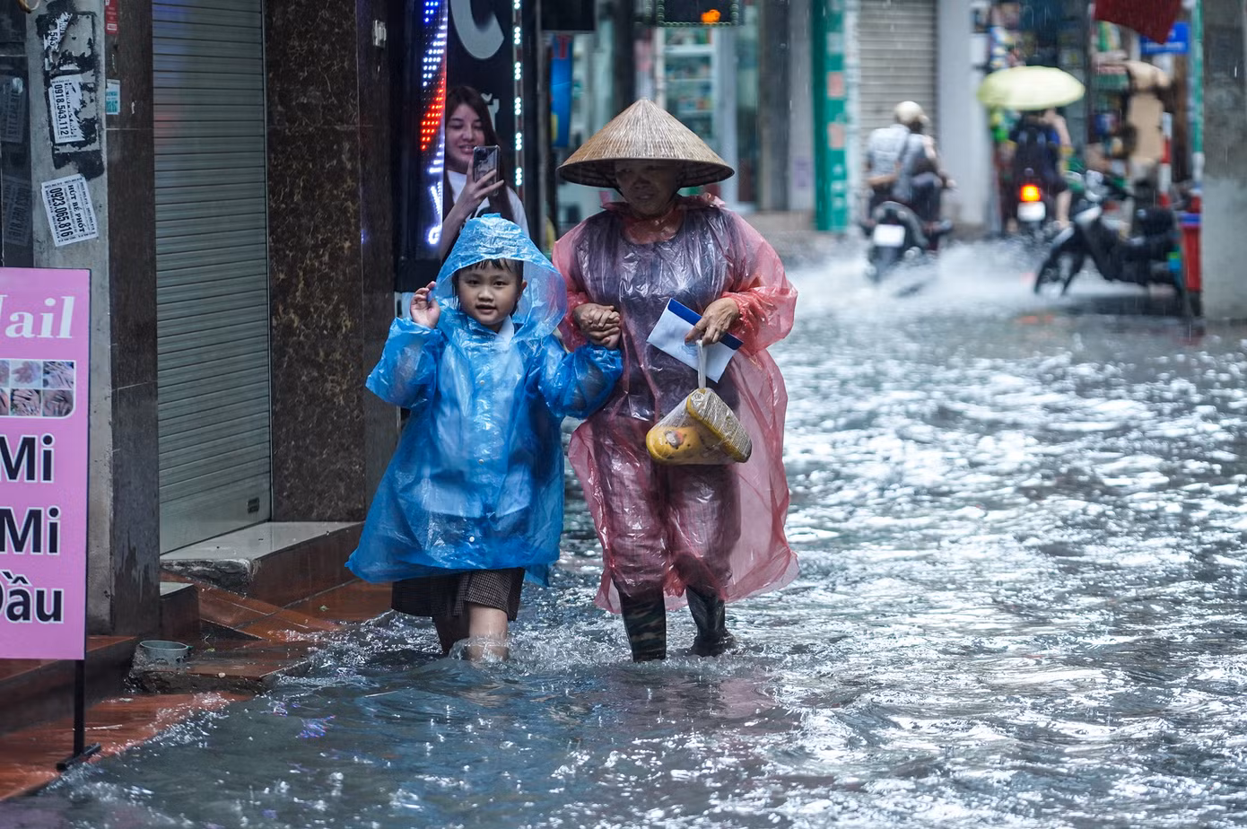 Mực nước dâng cao chừng 25cm gây khó khăn và nguy hiểm cho người tham gia giao thông.
