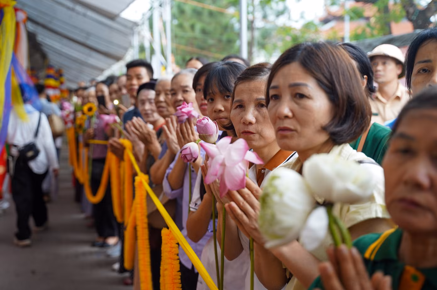Phật tử trong trang phục chỉnh tề, xếp hàng trang nghiêm trước cổng chùa.