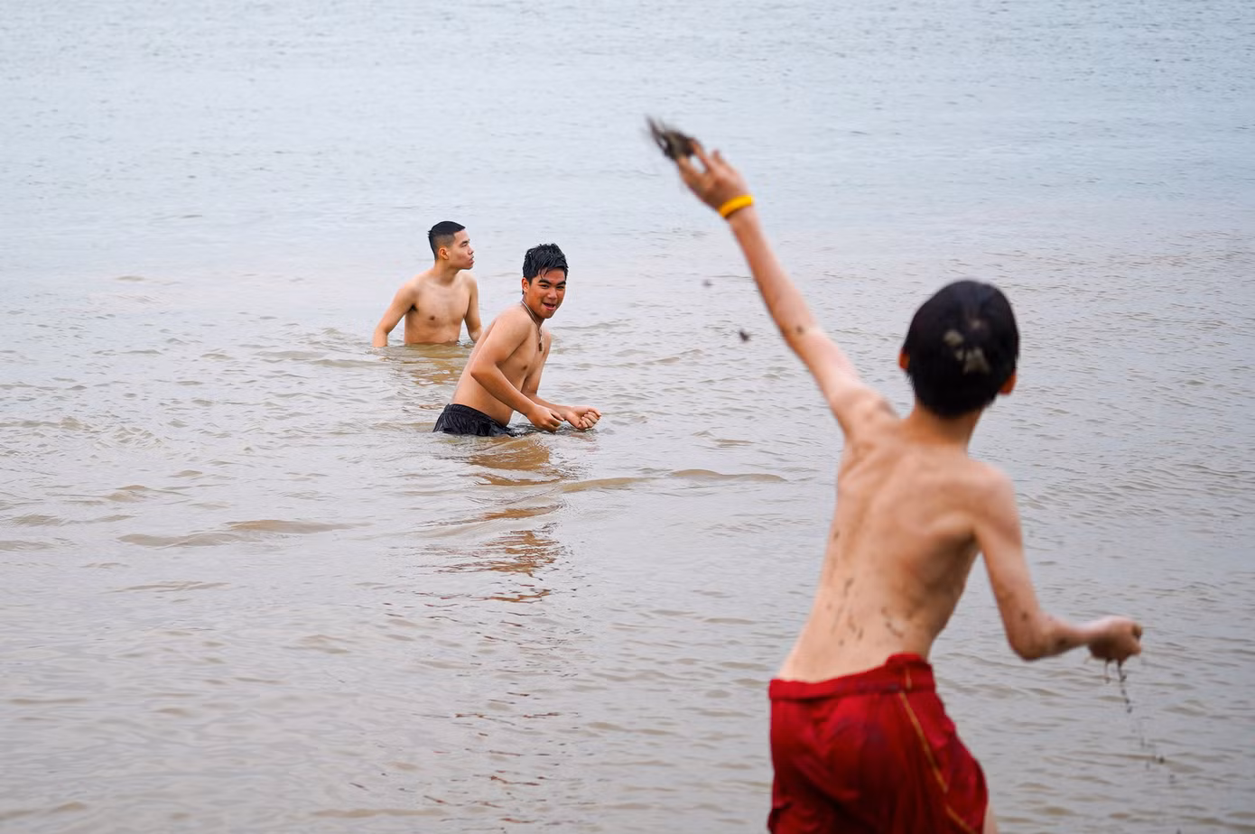 Nhiều bạn trẻ vui đùa cùng nhau trong làn nước mát của sông Hồng.