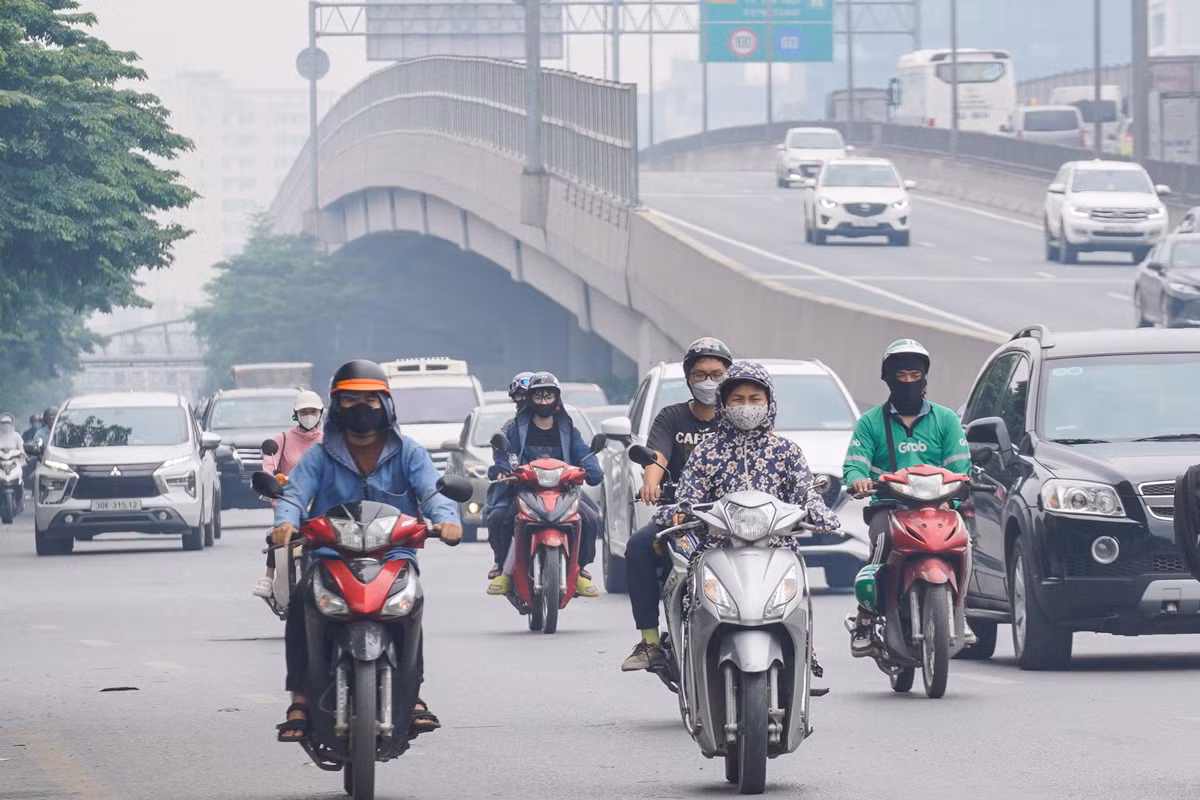 Lúc gần 13 giờ, đường Phạm Văn Đồng bị bao phủ bởi màn sương. Nhiều người dân di chuyển trên đường phải đeo khẩu trang kín mít để tránh ảnh hưởng sức khoẻ.