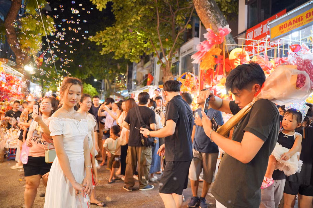 Dòng người đổ về phố Hàng Mã đông nghịt, chen chúc nhau để có được một góc ảnh đẹp.