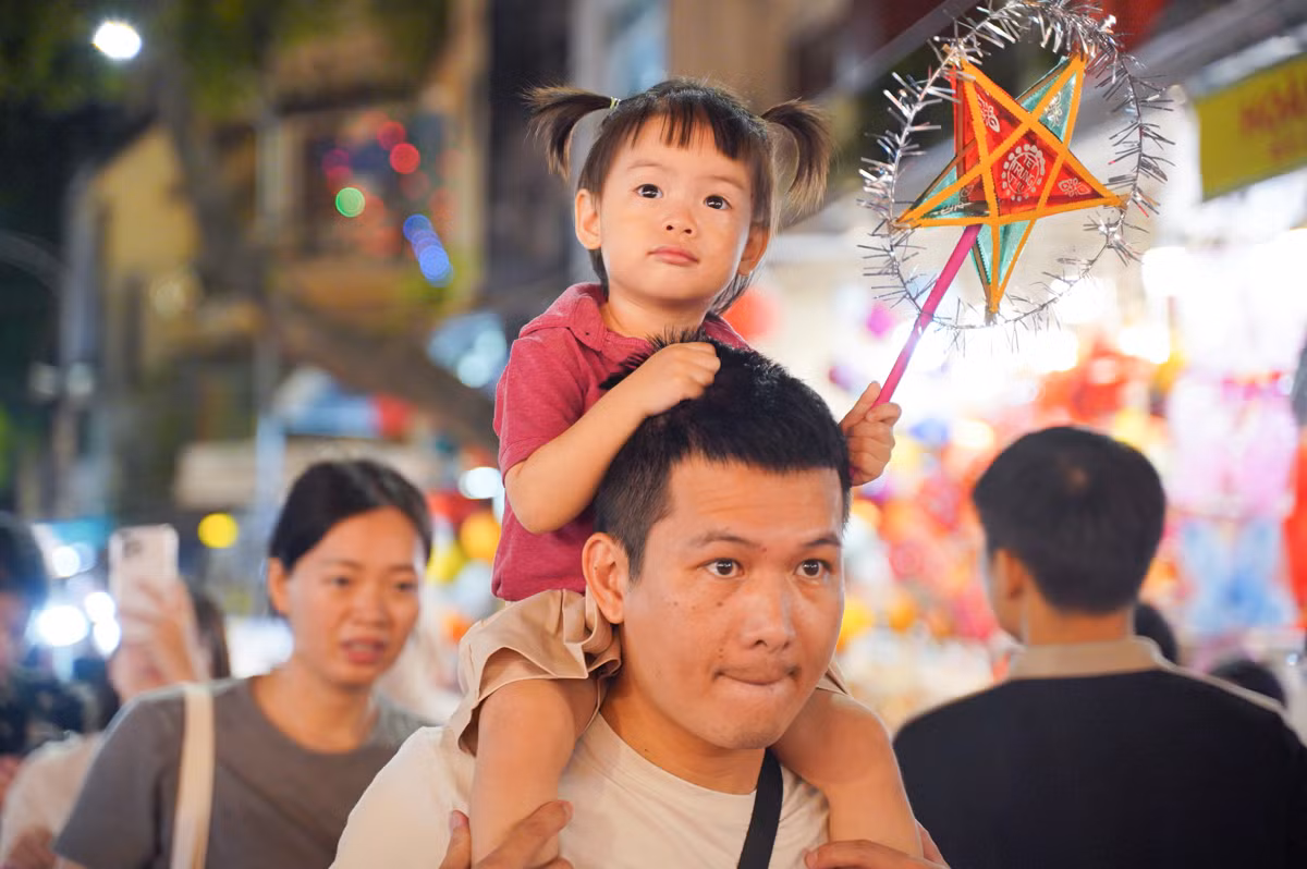 Nhiều gia đình đưa con nhỏ đi chơi Trung thu sớm. Tuy nhiên, do lượng người đổ về quá đông, các bậc phụ huynh phải bế con lên vai để các em có thể nhìn ngắm và tận hưởng không khí lễ hội.