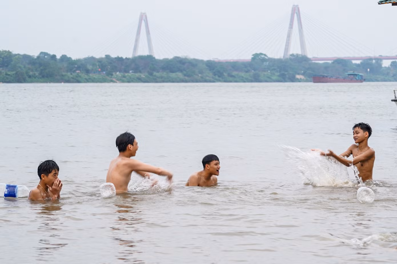 Nhiều bạn trẻ vui đùa cùng nhau trong làn nước mát của sông Hồng.