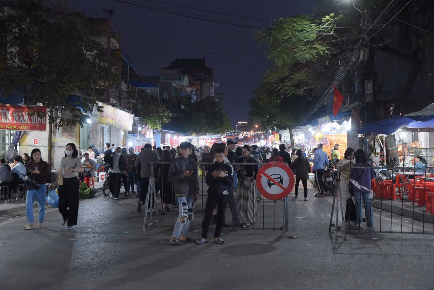 Chưa đến giờ họp chợ, thế nhưng nhiều người đã đến sớm để mua đồ. Tại chợ Viềng, người dân bày bán nông cụ, vật dụng làm nông nghiệp từ dao, liềm, cuốc, xẻng... đến cây hoa màu, cây cảnh. Trong ảnh: du khách mua hàng ở chợ Viềng để cầu may dịp đầu năm.