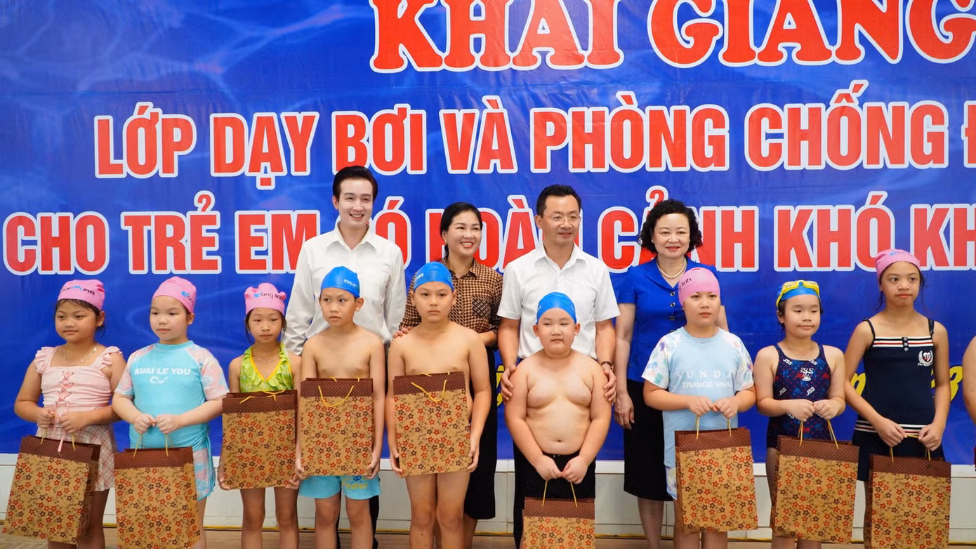 Đại diện Thành Đoàn Hà Nội và Ban tổ chức trao quà cho các em thiếu nhi có hoàn cảnh khó khăn tham gia lớp học bơi