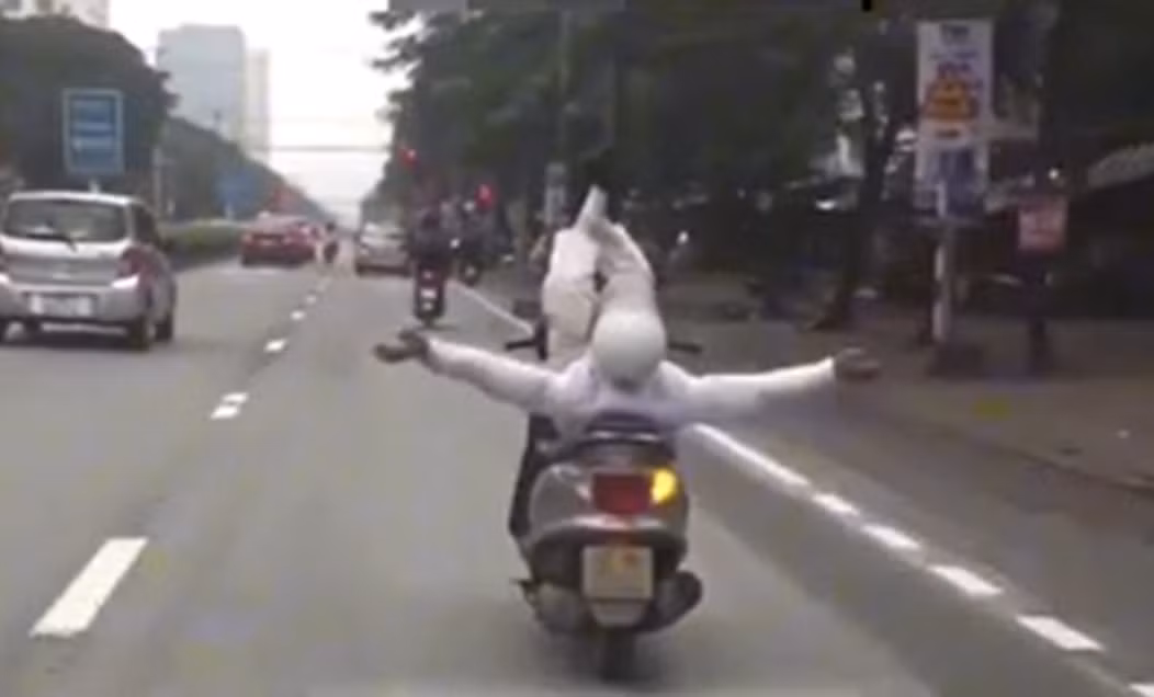 Hình ảnh người đàn ông dang hai tay hai chân khi điều khiển xe máy