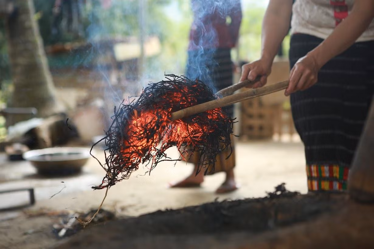Để giữ được tro tốt, người dân sẽ gắp những đống tro còn đỏ ửng vào trong chiếc cối đã đong sẵn gạo nếp.