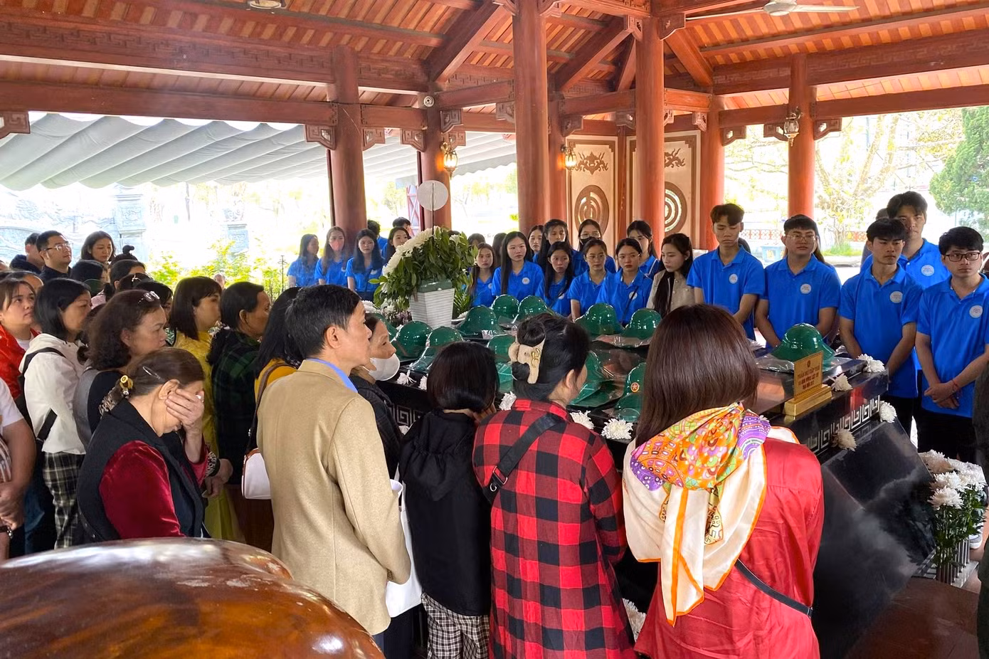 Bên ngôi mộ chung, du khách lắng lòng nghe thuyết minh viên kể lại giây phút hy sinh đầy xúc động của 13 liệt sĩ thanh niên xung phong.