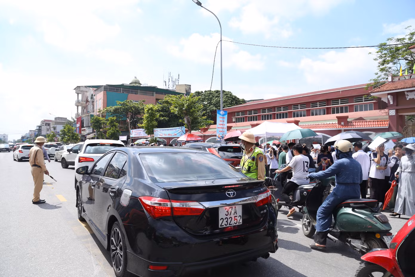 Tại cổng điểm thi Trường THPT Huỳnh Thúc Kháng nằm trên đường Lê Hồng Phong, thành phố Vinh, kết thúc giờ thi môn Ngữ Văn, có rất đông phụ huynh tập trung khu vực gần trường. Lưu lượng phương tiện tham gia trên tuyến đường đông khiến giao thông tại đây hỗn loạn. Để đảm bảo giao thông thông suốt, Tổ Cảnh sát giao thông địa bàn thành phố Vinh thuộc Phòng Cảnh sát giao thông Công an Nghệ An đã phân luồng, điều tiết giao thông.