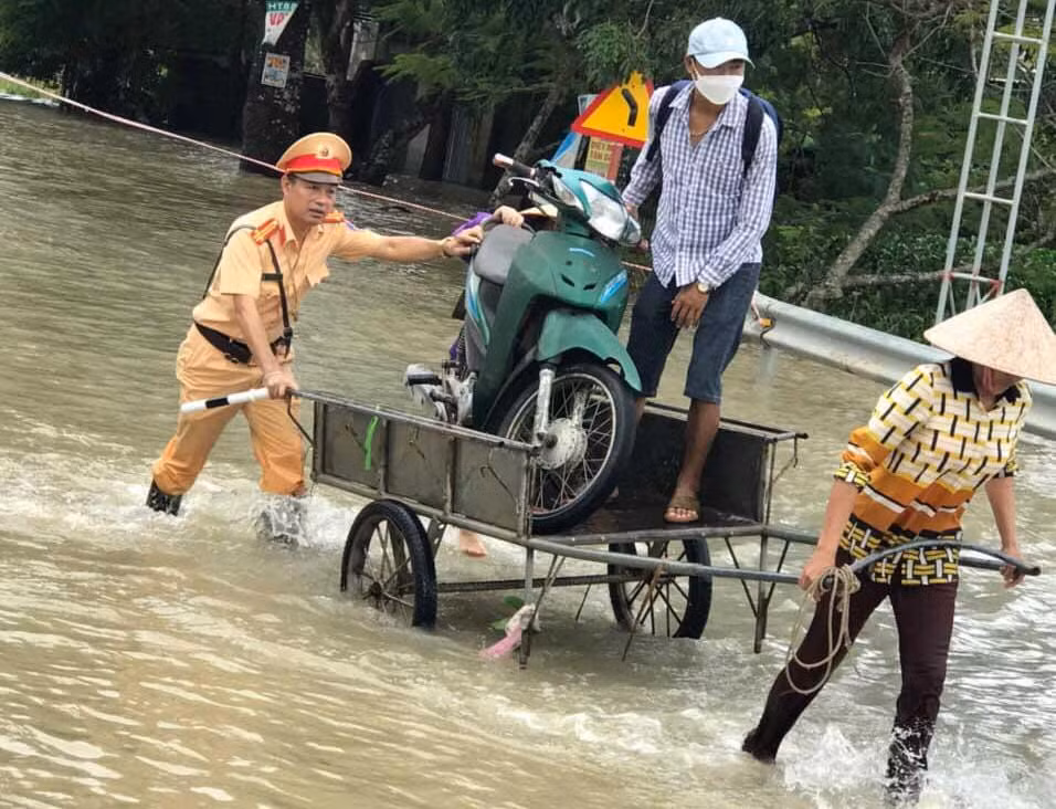 Công an giúp đỡ người dân và phương tiện di chuyển qua các tuyến đường bị ngập sâu