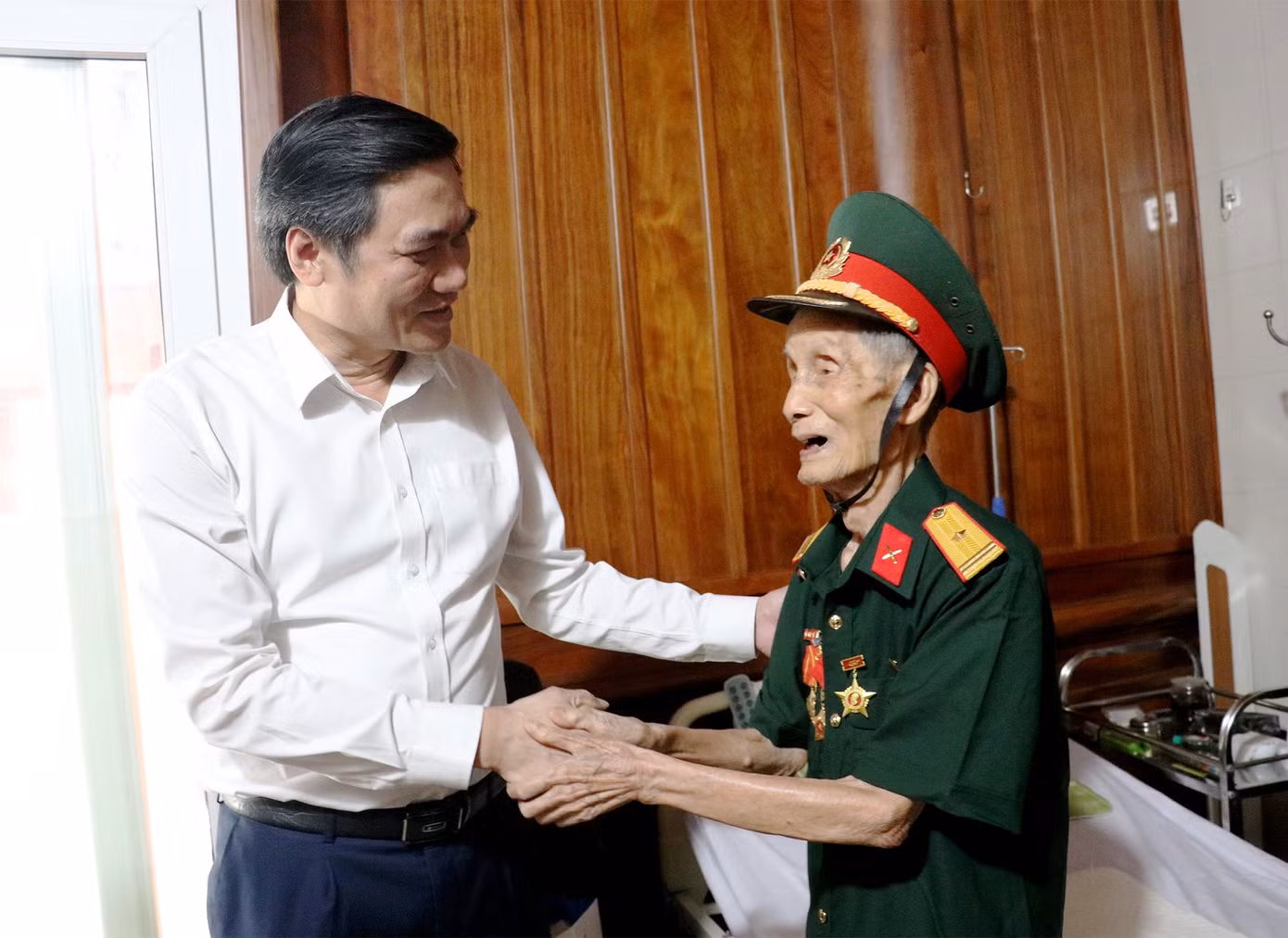 Phó Bí thư Tỉnh ủy Nghệ An Hoàng Nghĩa Hiếu ân cần hỏi thăm sức khỏe cựu chiến sĩ Điện Biên Bùi Đình Hòe.