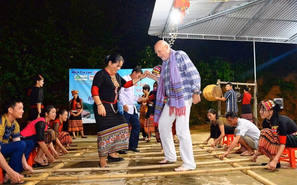 Du khách nước ngoài say sưa với điệu nhảy sạp tại điểm du lịch cộng đồng bản Khe Rạn, xã Bồng Khê, huyện Con Cuông