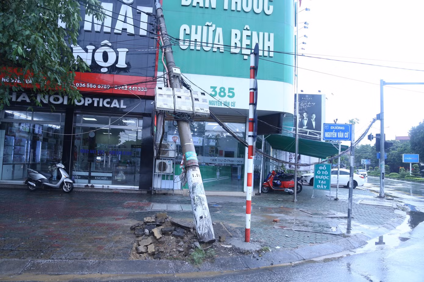 Cột điện tại ngã tư Nguyễn Văn Cừ giao với đường Nguyễn Sỹ Sách bị nghiêng đổ vào nhà dân.