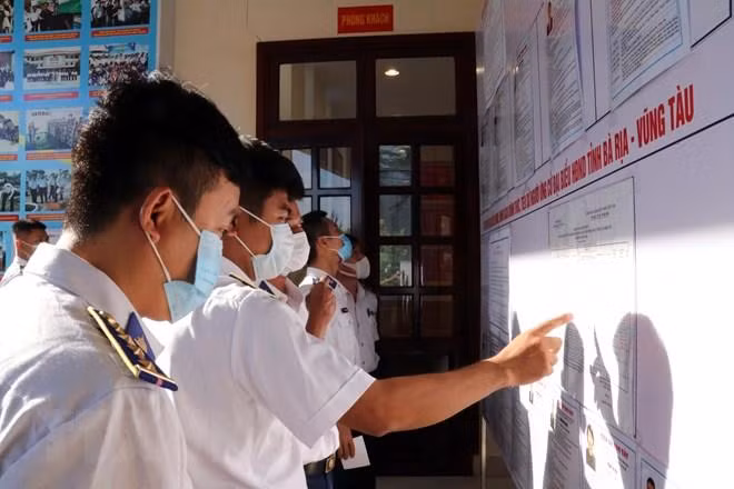 Cán bộ, chiến sỹ tìm hiểu thông tin ứng cử viên tại Trụ sở Cảnh sát biển Vùng 3. (Ảnh: Đoàn Mạnh Dương/TTXVN)