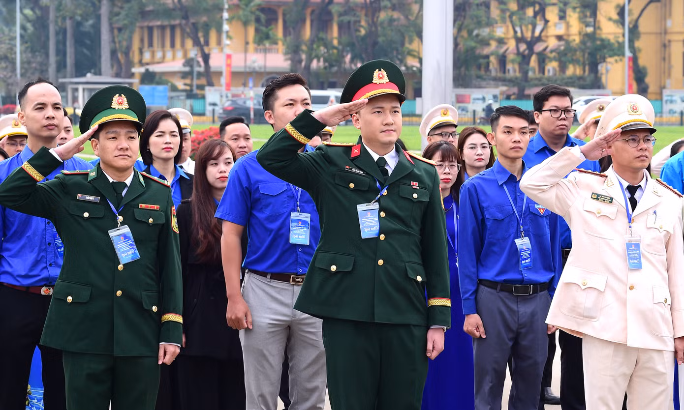 Các đại biểu nghiêm trang thực hiện nghi thức chào cờ tại lễ báo công dâng Bác. Ảnh: Xuân Tùng