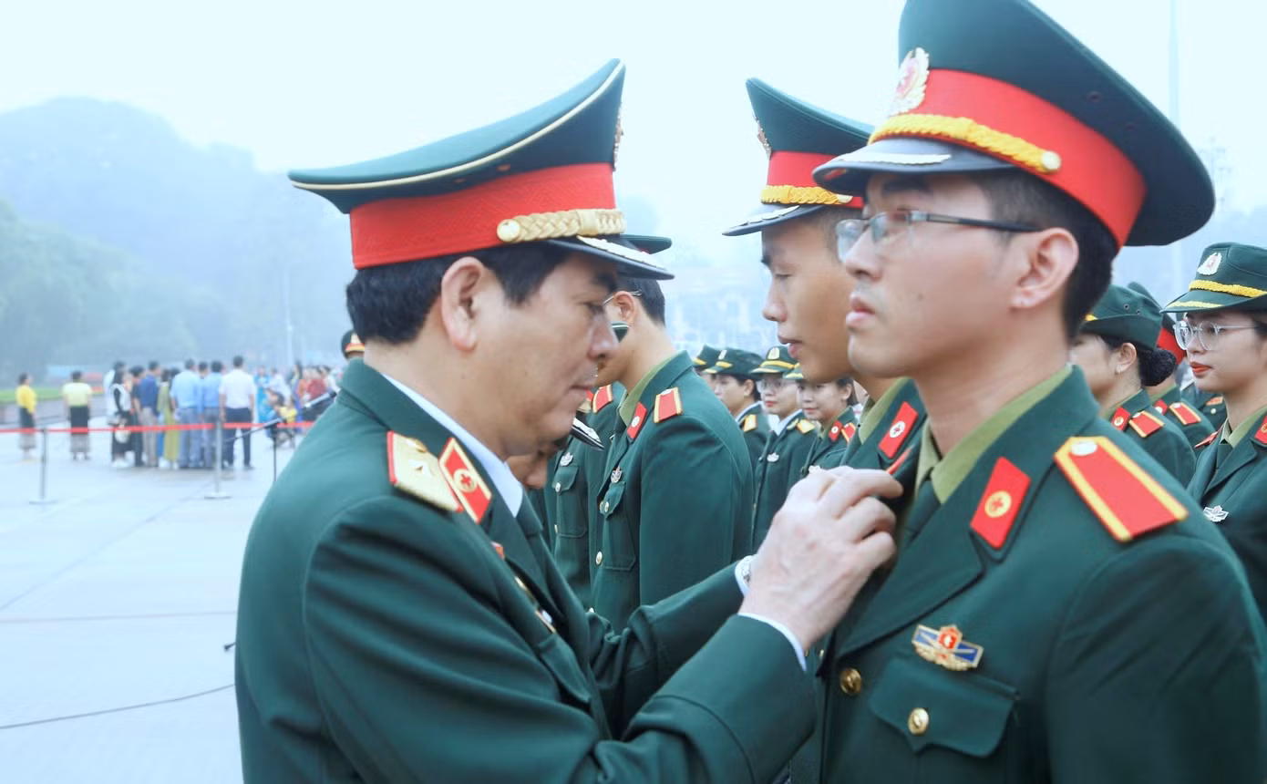 Thiếu tướng Nghiêm Đức Thuận - Chính ủy Học viện Quân y, gắn Huy hiệu Bác Hồ tặng học viên tốt nghiệp loại giỏi, tại lễ báo công.