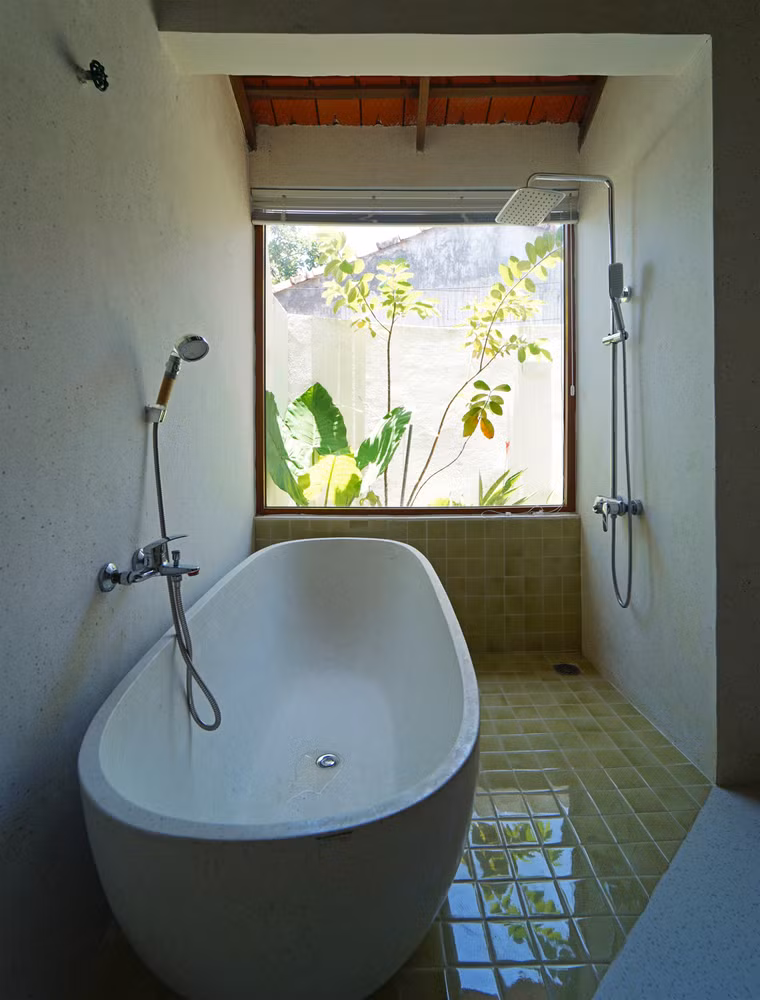 Phòng tắm với view nhìn ra khu vườn xanh mát.