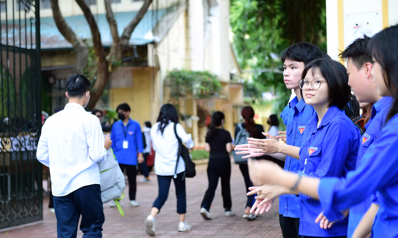 Các tình nguyện viên hỗ trợ, hướng dẫn thí sinh nơi gửi xe, gửi đồ, vị trí phòng thi; phát tặng nước uống miễn phí, cổ vũ tinh thần thí sinh tự tin bước vào phòng thi. Ảnh: Tường Kha