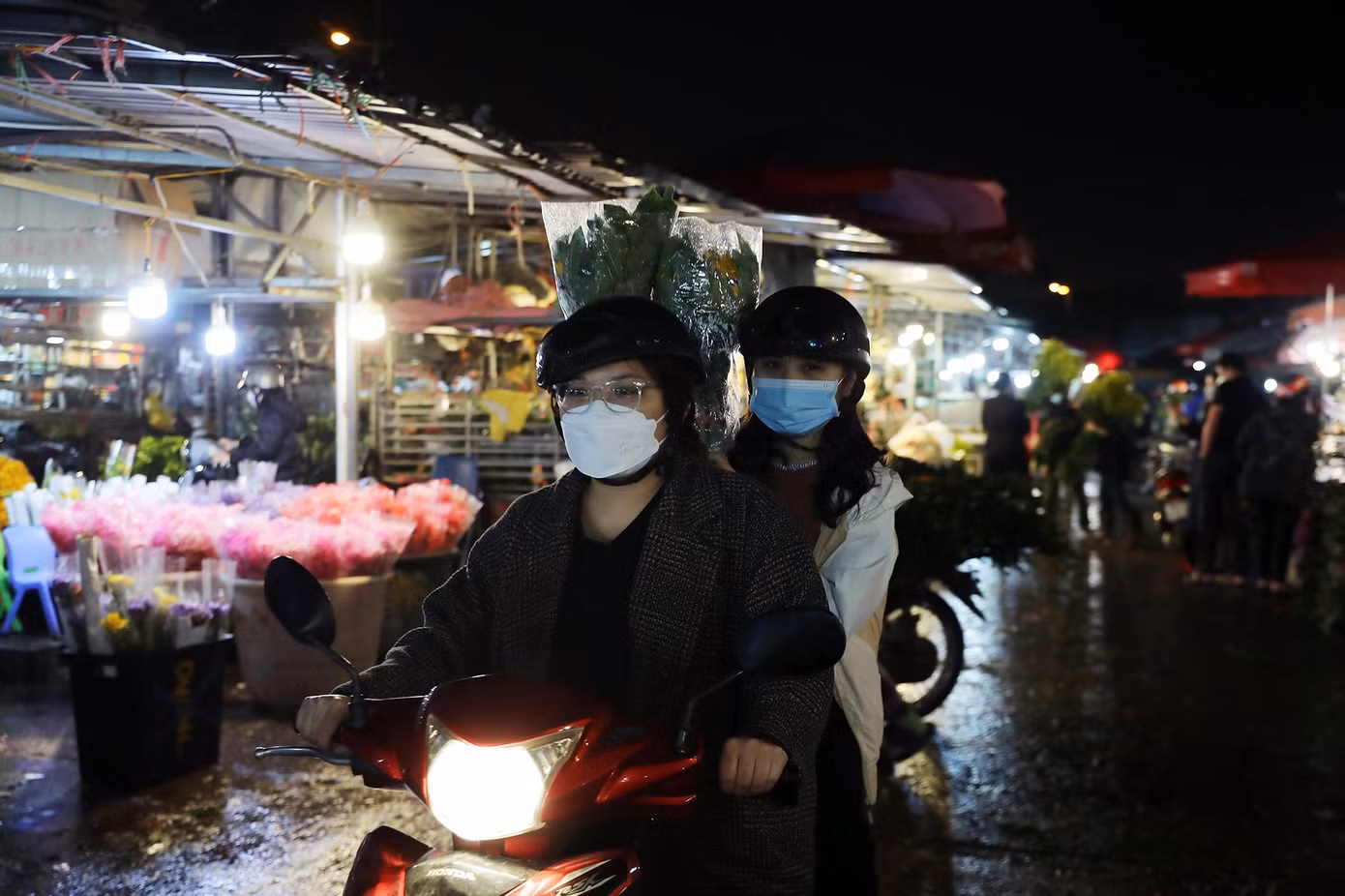 Ngoài các tiểu thương, chợ hoa Quảng Bá cũng thường xuyên đón các khách mua lẻ. Trong ảnh là hai cô gái đi mua hoa trong đêm.