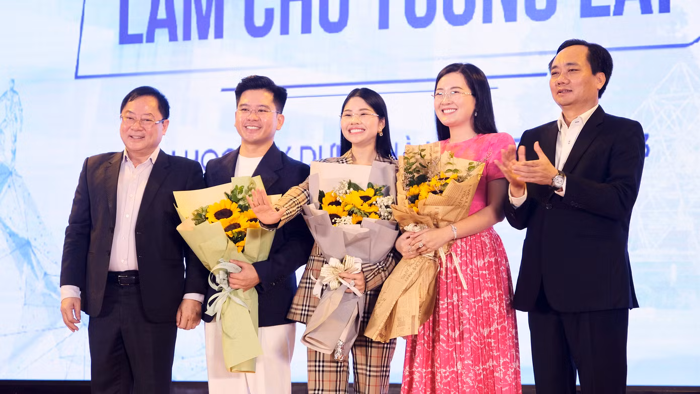 Nhà báo Lê Xuân Sơn (bên trái) và PGS.TS Phạm Xuân Anh (bên phải) tặng hoa cảm ơn diễn giả Lang Công Đạt, chị Nguyễn Diệu Thu, chị Nguyễn Thị Thạch Thảo.