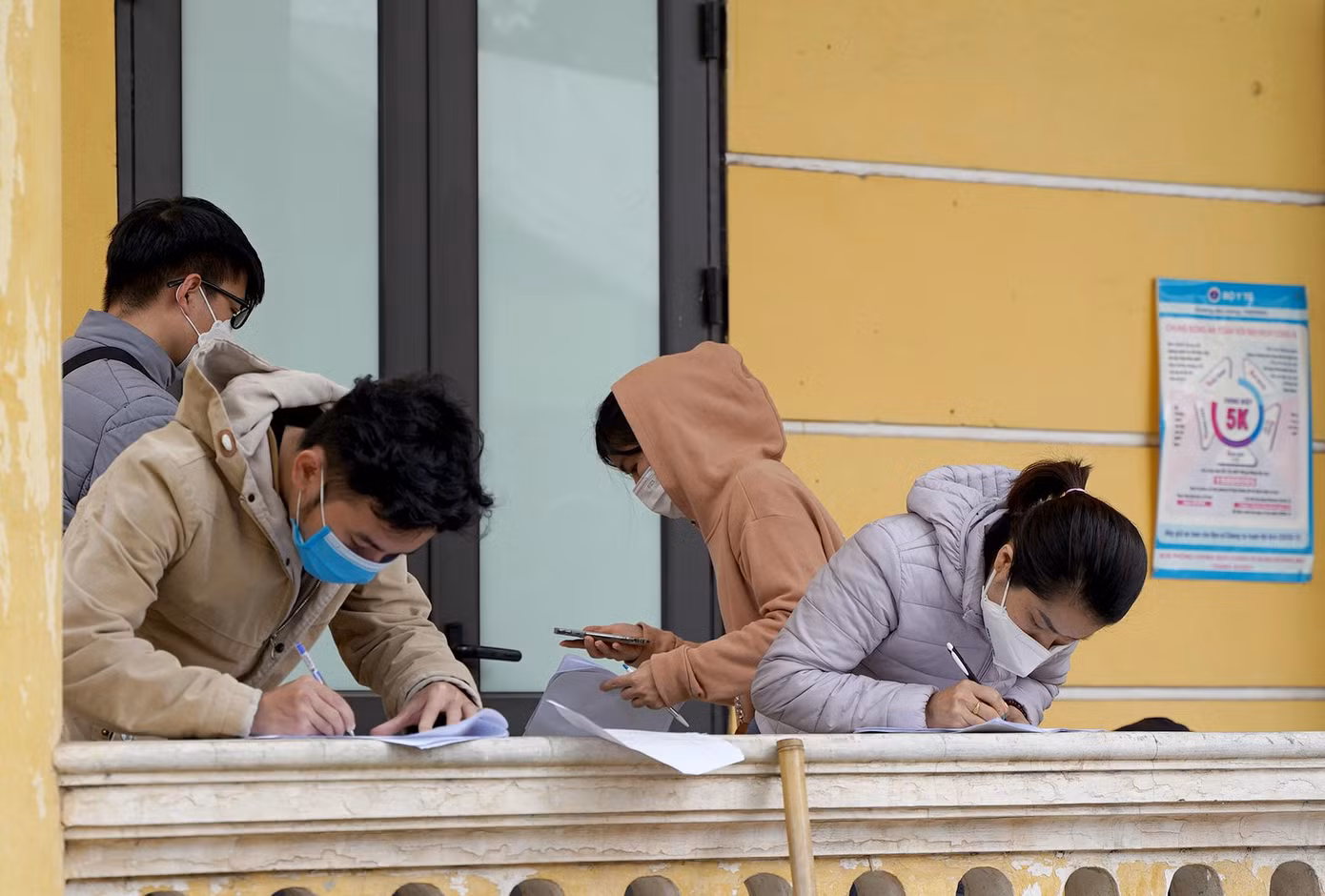 Người dân tranh thủ đứng khai báo y tế dọc hành lang của nhà văn hóa phường Hoàng Liệt.