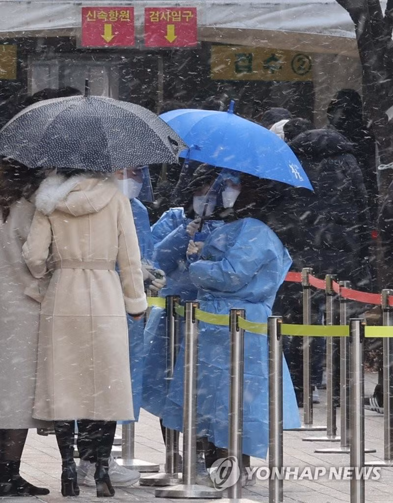 Người dân Seoul đi xét nghiệm dưới trời mưa tuyết. Ảnh: Yonhap