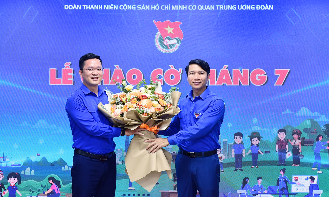Anh Nguyễn Ngọc Lương tặng hoa chúc mừng Ngày truyền thống lực lượng thanh niên xung phong tại chương trình. Anh Vũ Huy Dương - Phó Trưởng Ban TNXP T.Ư Đoàn, Phó Chỉ huy Trưởng Lực lượng TNXP Trung ương, đại diện đón nhận. Ảnh: Xuân Tùng