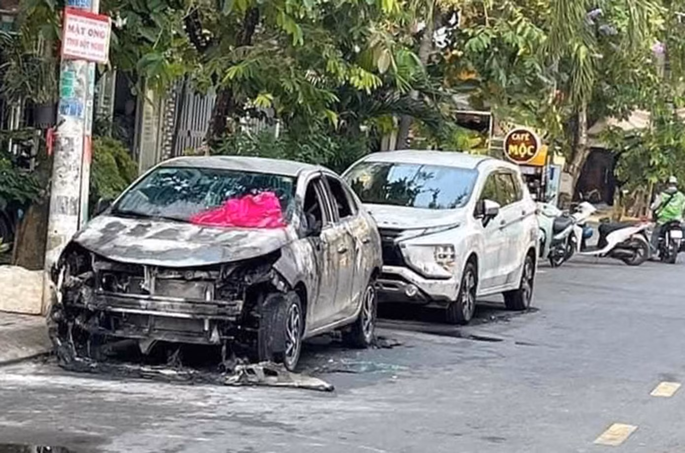 Hai chiếc xe ô tô đậu sát nhau bị đốt cháy.