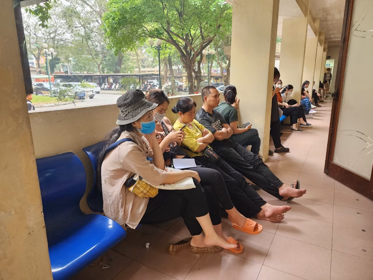 Nhiều người ngồi ngoài hành lang chờ đến lượt.