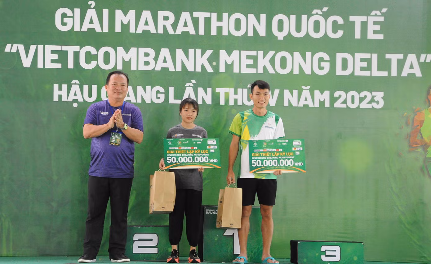 Ông Nguyễn Văn Hòa - Phó Chủ tịch UBND tỉnh Hậu Giang, Trưởng Ban tổ chức trao chứng nhận thiết lập kỷ lục cho VĐV Hoàng Nguyên Thanh và Lê Thị Tuyết ở cự ly 42km.