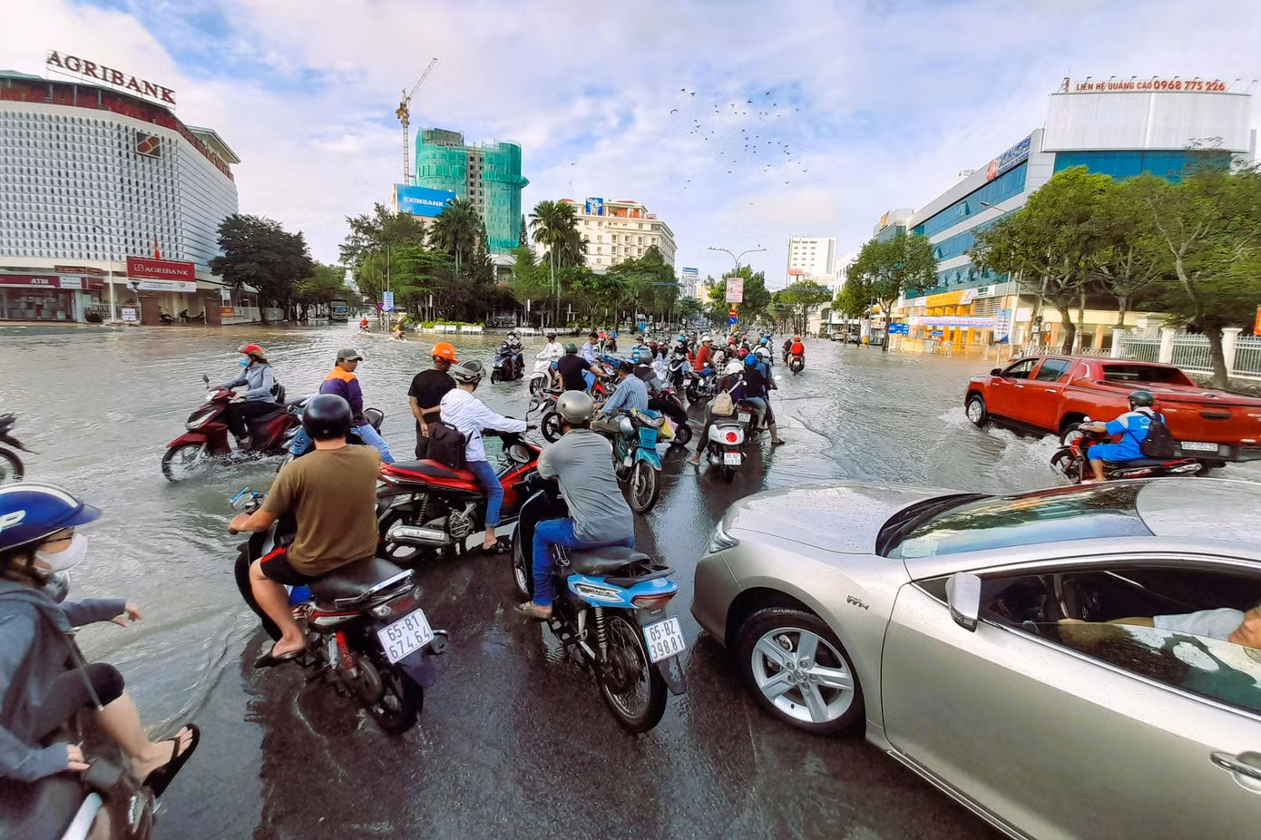 Nước bủa vây, nhiều người chấp nhận trễ giờ, đợi nước rút bớt mới đi tiếp.