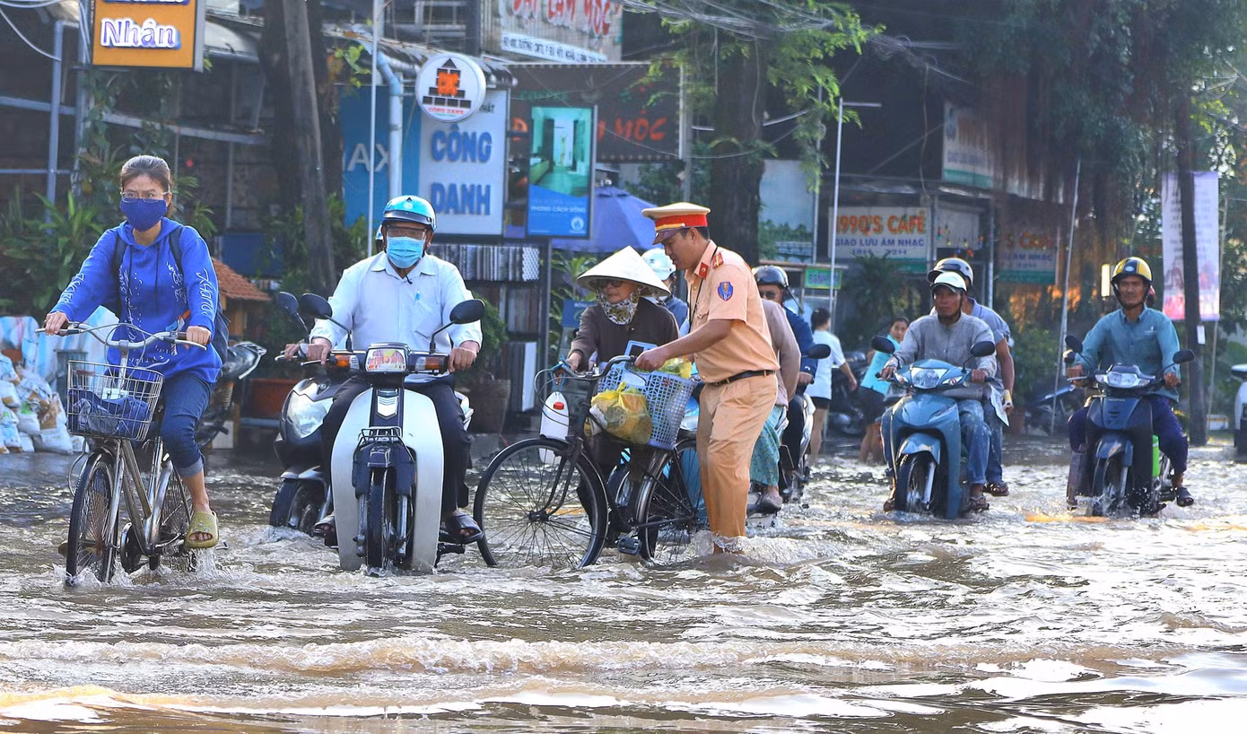 Lực lượng công an, đoàn viên thanh niên giúp đỡ người dân đi qua vùng ngập sâu. Lực lượng công an, đoàn viên thanh niên giúp đỡ người dân đi qua vùng ngập sâu.