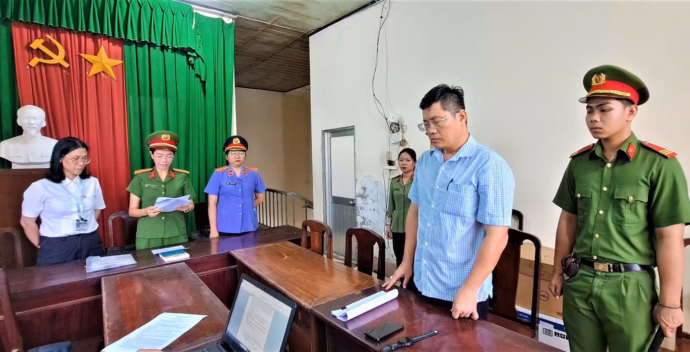 Công an tống đạt quyết định khởi tố bị can đối với Ngô Tấn Quốc (trái) và Phùng Ngọc Ngoan.
